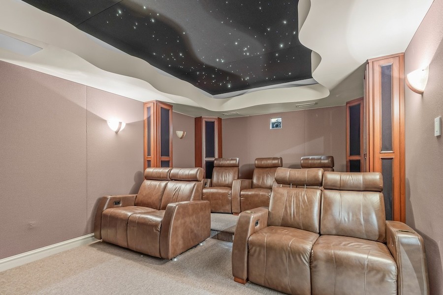 fiber optic starlight ceiling above two rows of brown leather recliners in a home theater room