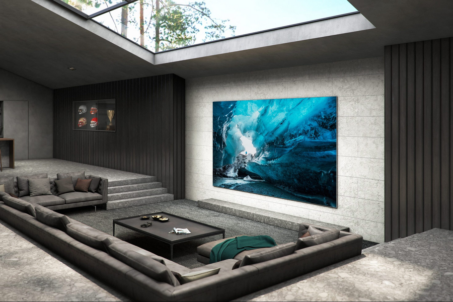 A home media room with conversation pit-style seating, a large TV screen, and a sunroof.