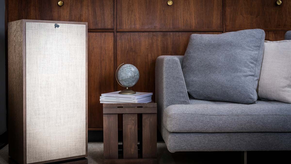 klipsch speaker next to bookshelf and couch