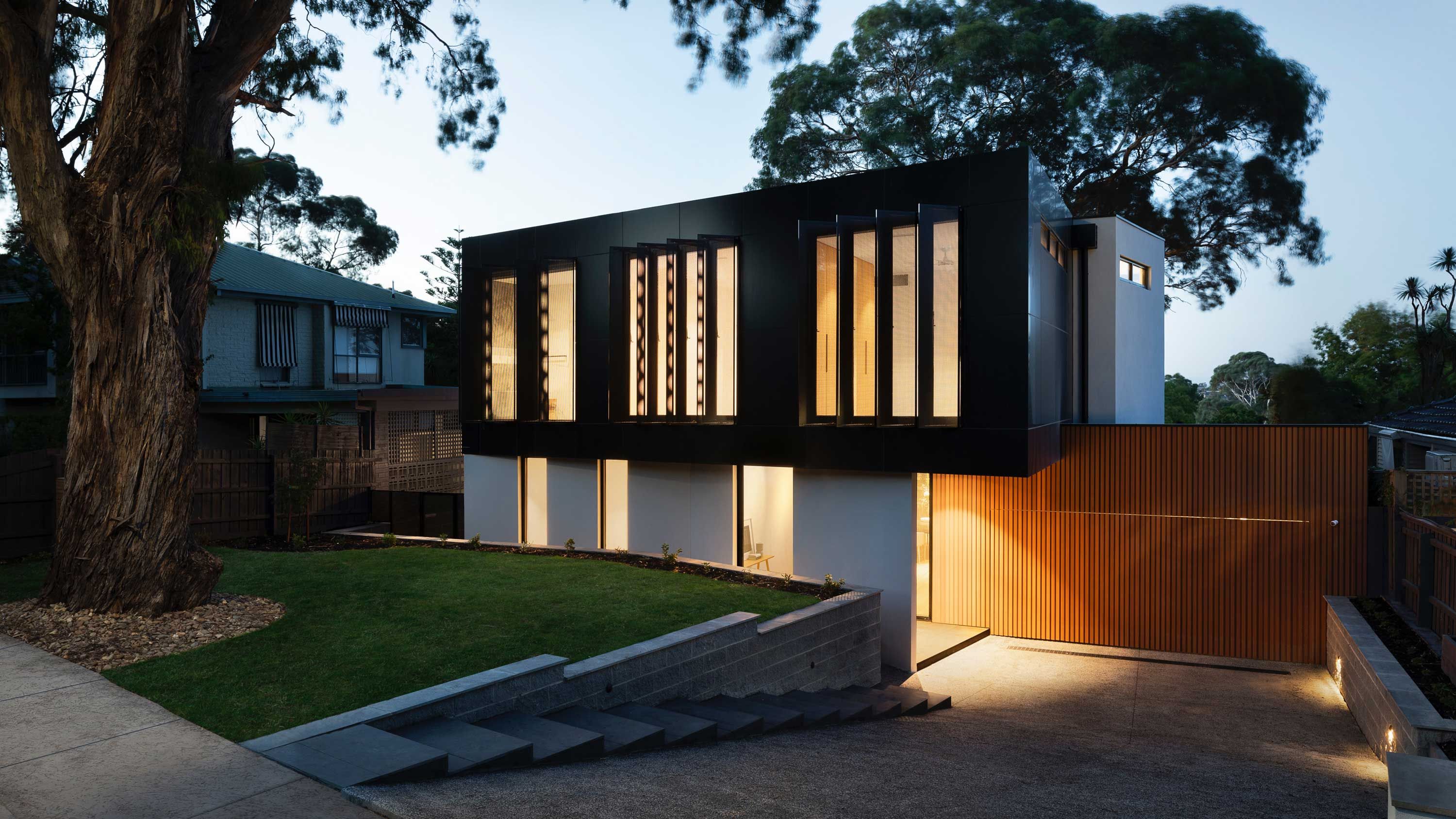 modern home lit up at dusk